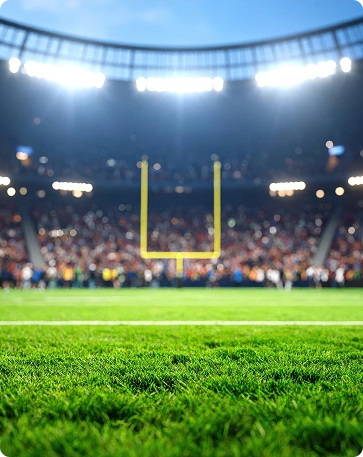 Um estádio de futebol profissional cheio de espectadores sob potentes luzes de estádio, apresentando um campo bem cuidado pronto para competições e grandes eventos desportivos.